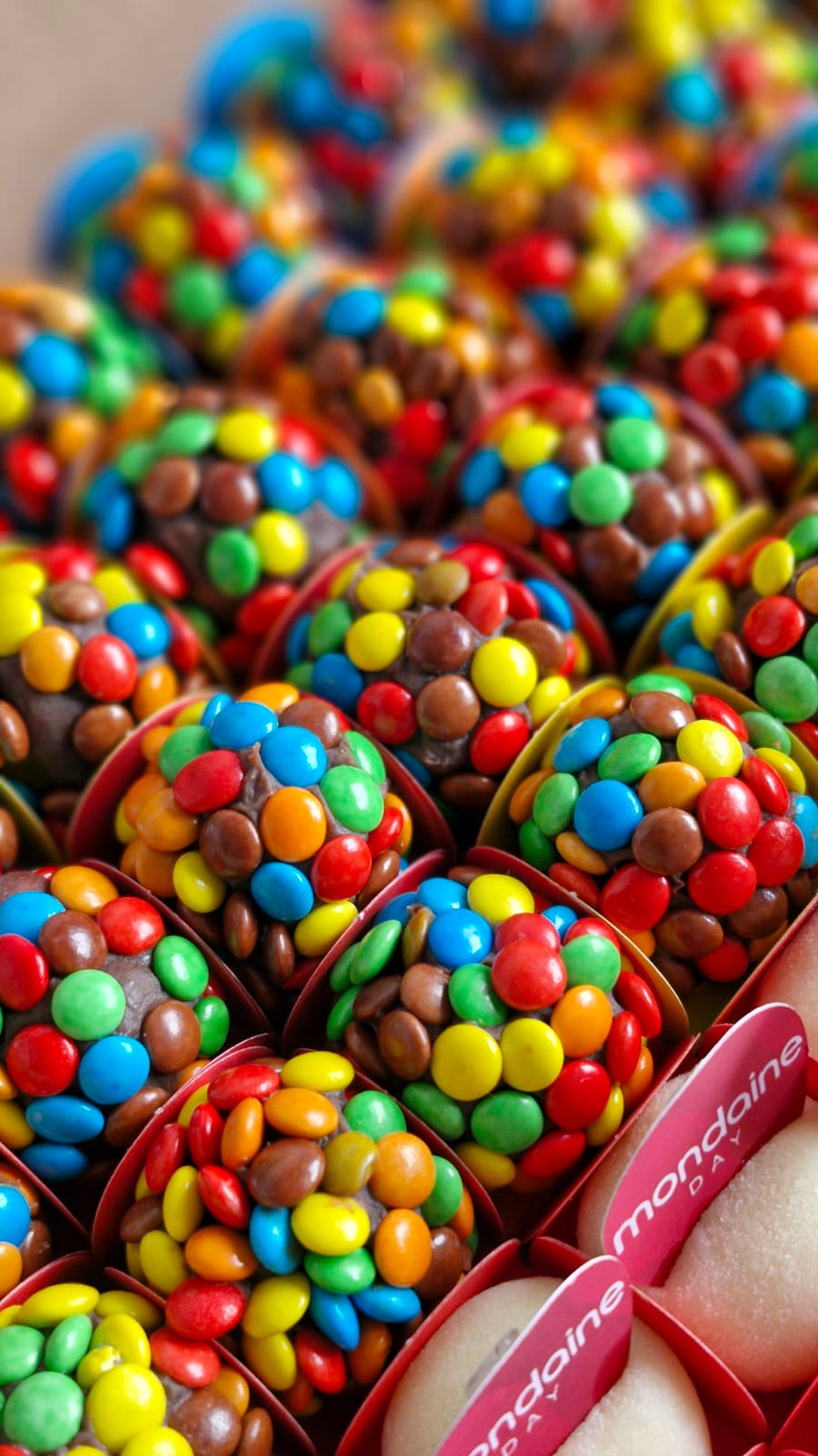 Brigadeiros gourmet cobertos com chocolatinhos coloridos — doces para festa em Avaré